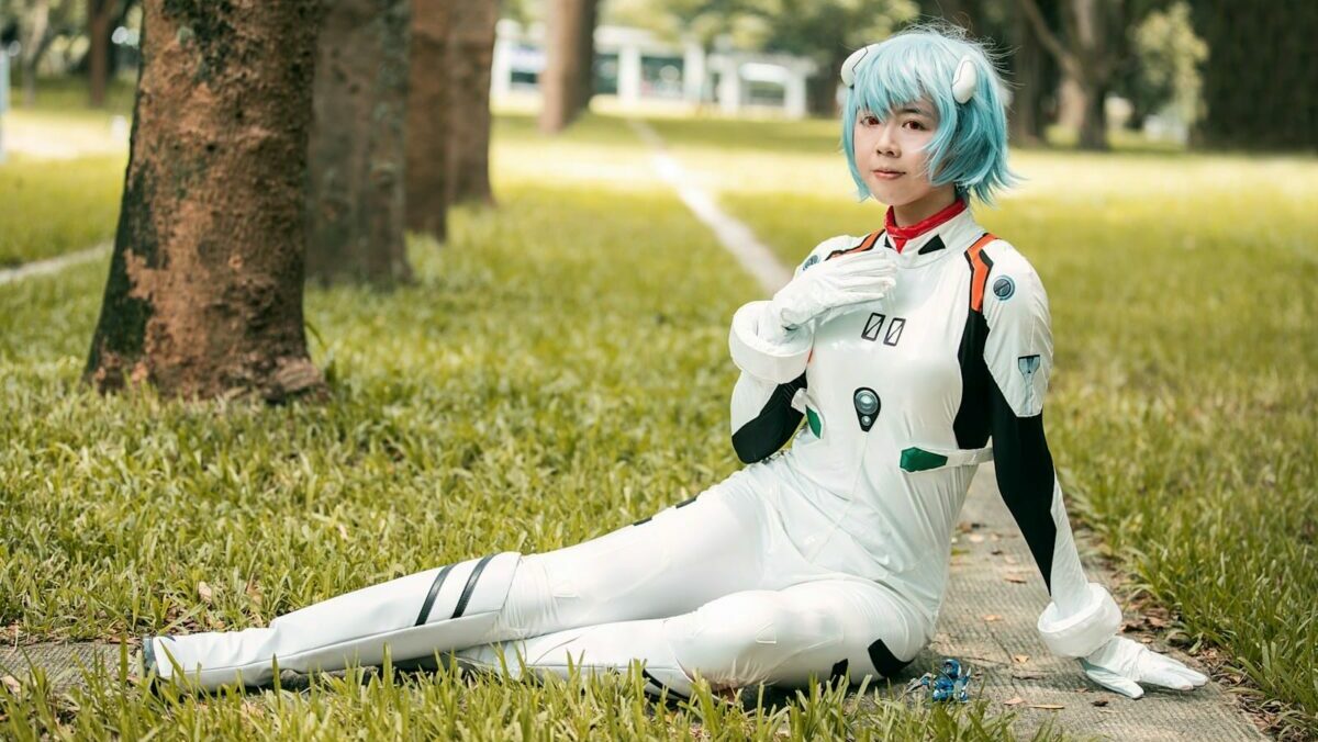 boy in white and black long sleeve shirt and pants sitting on green grass field during